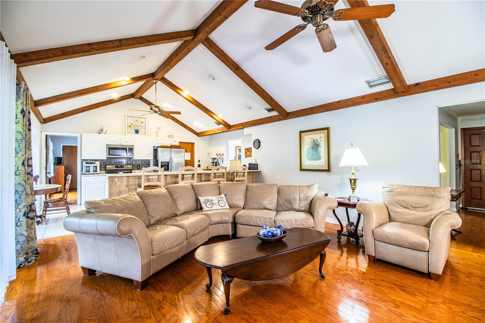 Beamed ceilings connect the open family room space to the stylish kitchen.