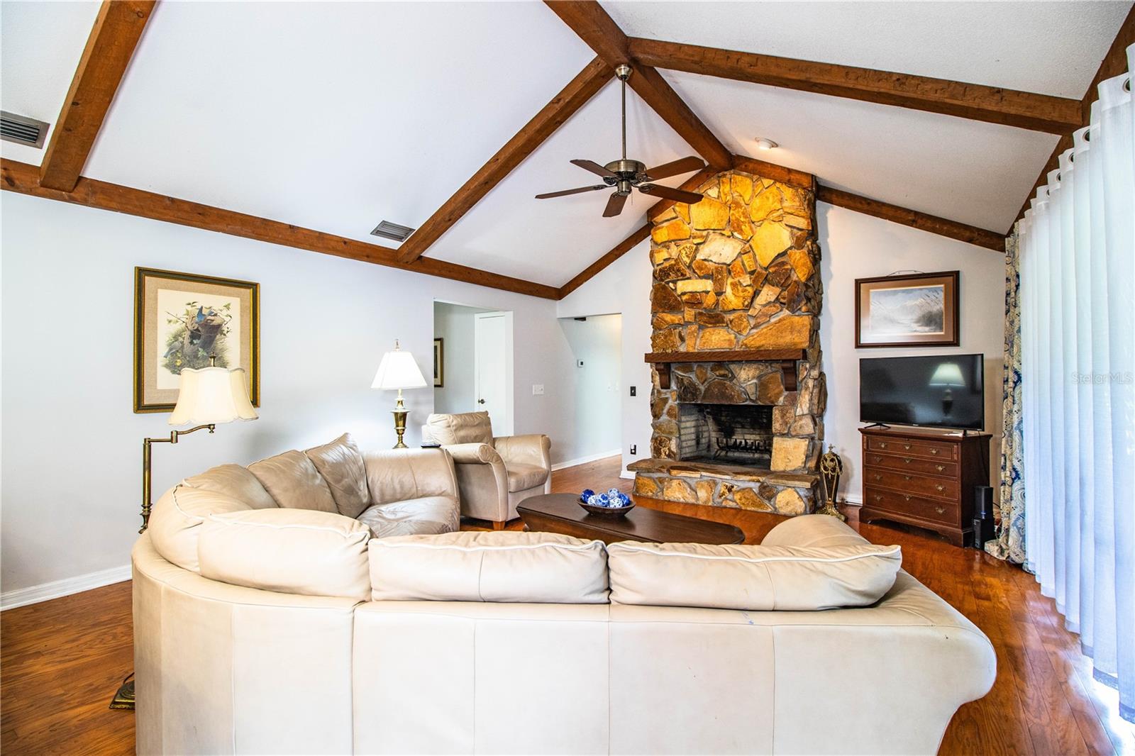Bright and open family room with views into the kitchen and rustic beam charm.