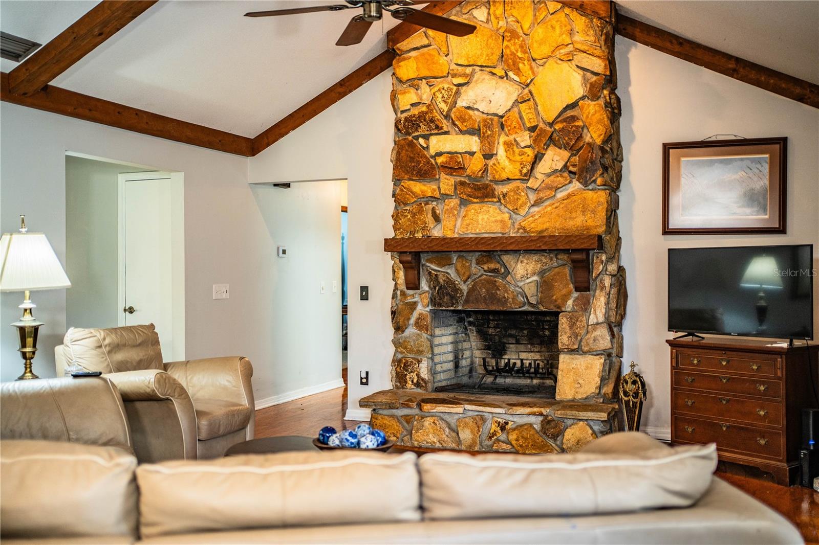 A stunning fireplace and warm wood tones anchor the family room’s comfortable ambiance.