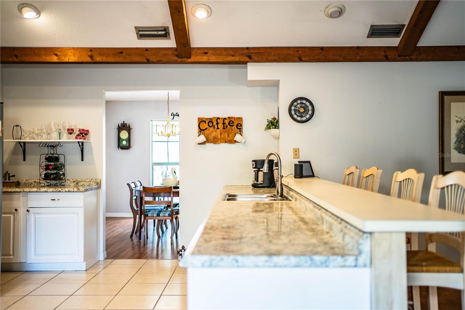 Light-filled kitchen with bar seating, a coffee station, and stylish updated cabinetry.