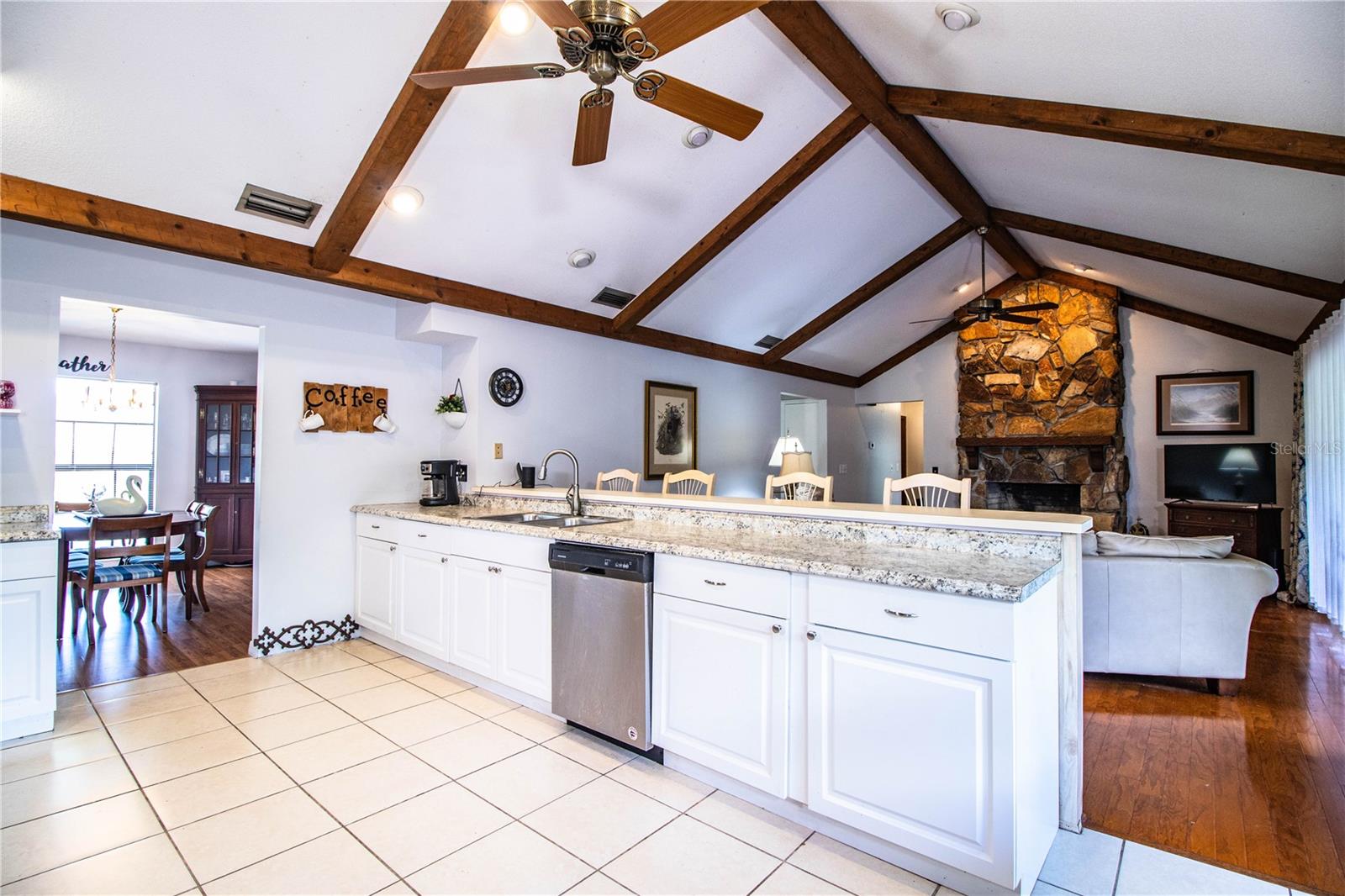 Beautifully updated kitchen with tile throughout, bar seating, and abundant windows.