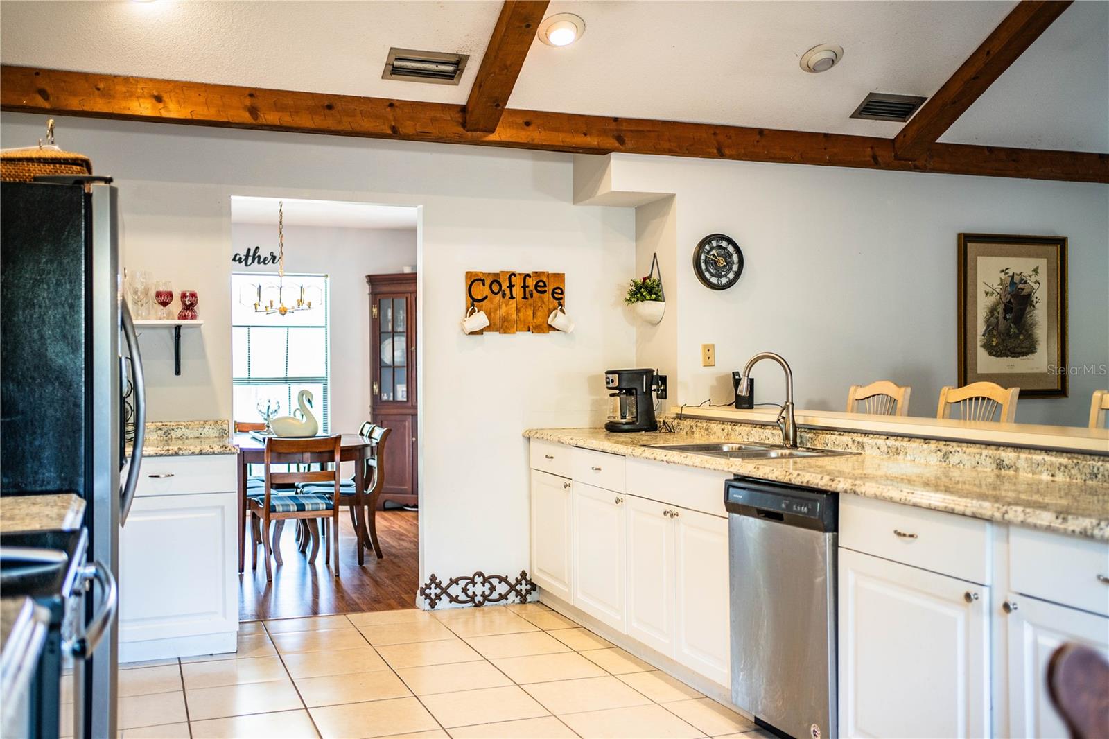 Charming kitchen with a large breakfast bar, cozy dinette area, and sleek stainless appliances.
