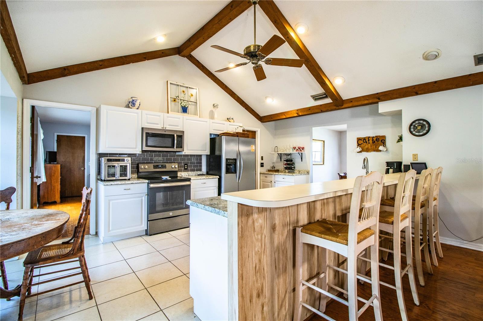 Open-concept family room and kitchen area with eye-catching beam details.