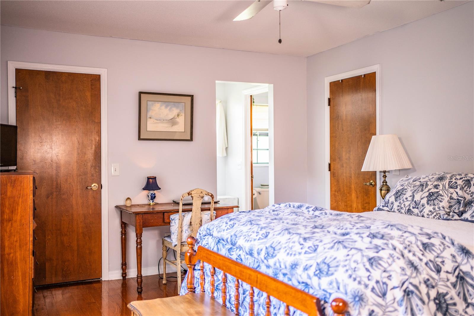 Step into a large primary bedroom retreat featuring rich hardwood floors and plenty of room for a king-sized bed.