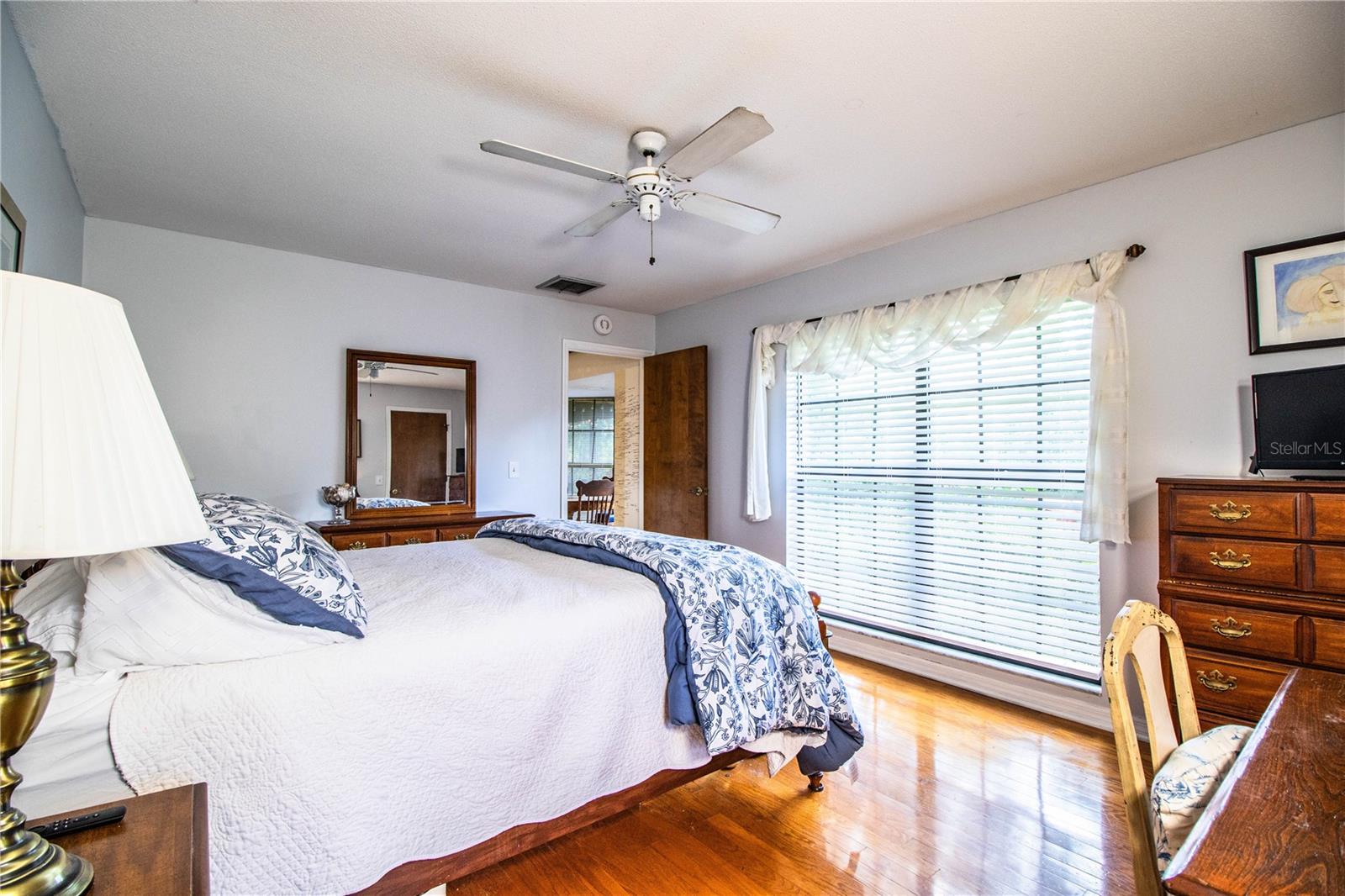 Beautiful hardwood flooring brings warmth and character to this generously sized primary bedroom.