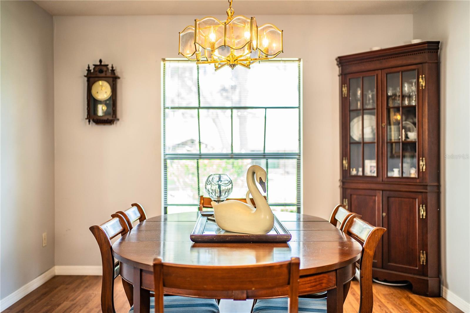 Elegant formal dining room with gleaming hardwood floors and large window views.