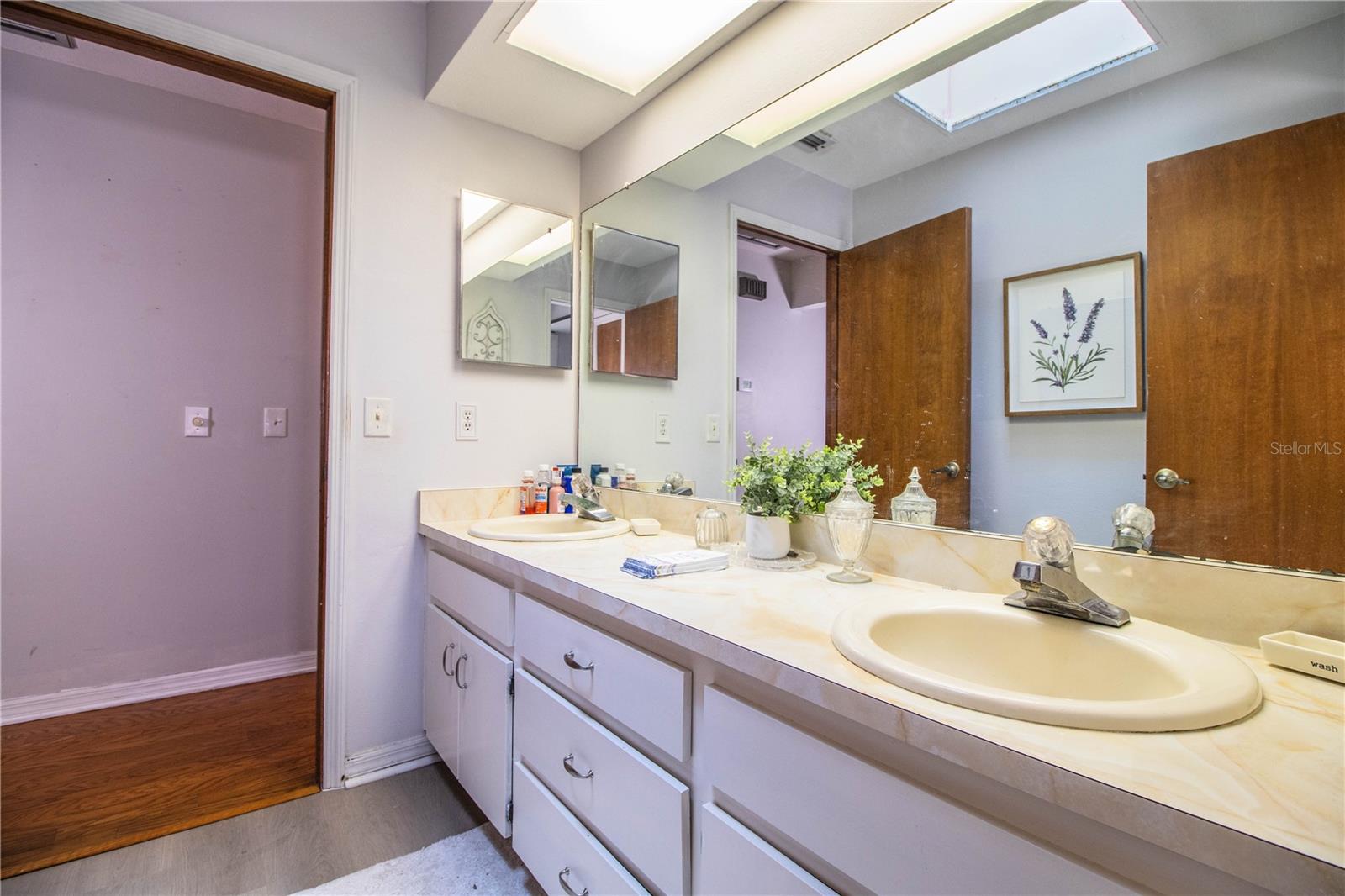 Spacious and well-appointed, the guest bath features double sinks, great lighting, and a separate water closet for privacy and functionality.