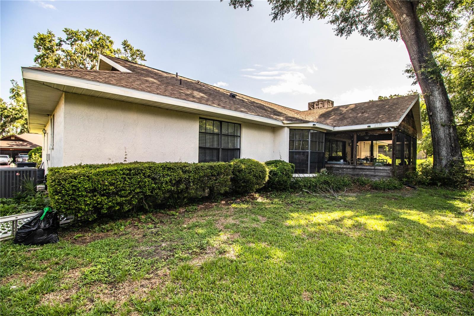 The expansive backyard is lined with lush landscaping, offering both privacy and natural beauty.