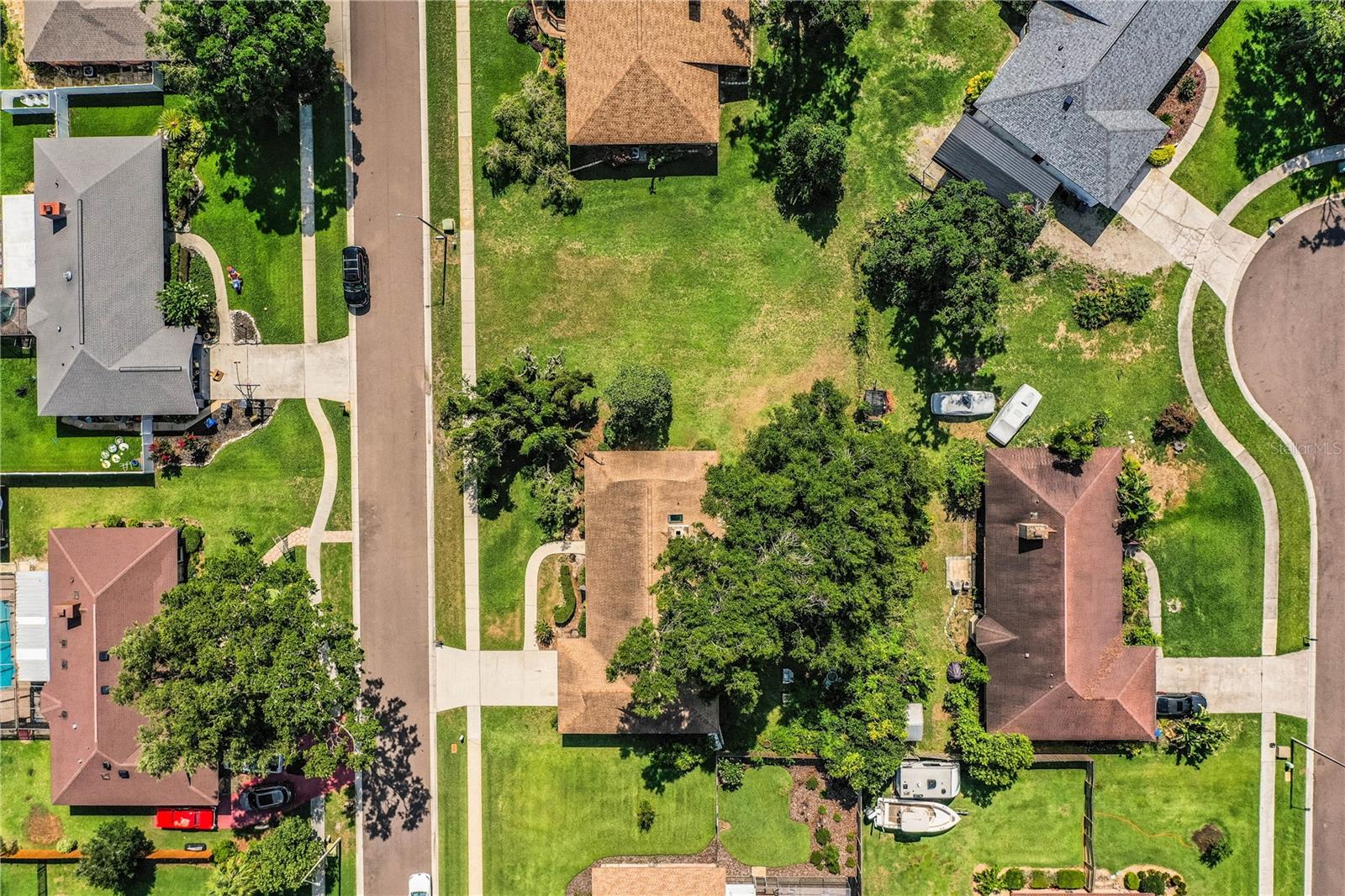 The aerial view reveals the expansive 1/3+ acre lot—all open space ready to create your dream garden, retreat, or play area.