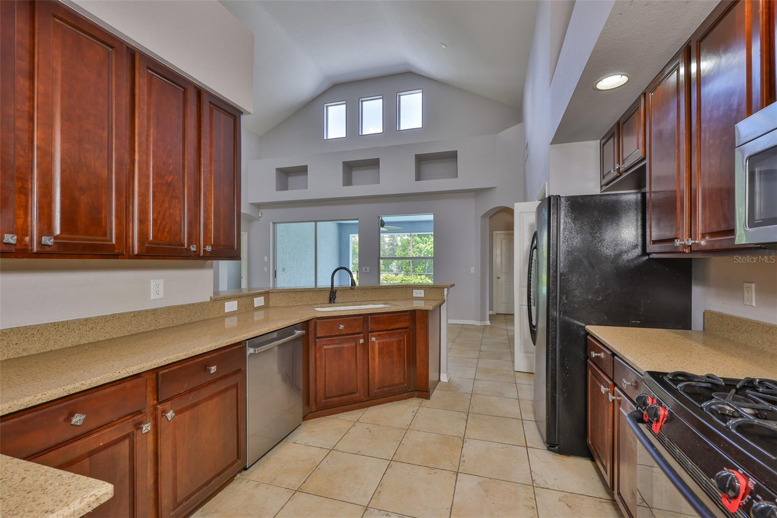 Chef's kitchen, granite counters, lots of wood cabinets, recessed lighting over cabinets and in vaulted ceiling