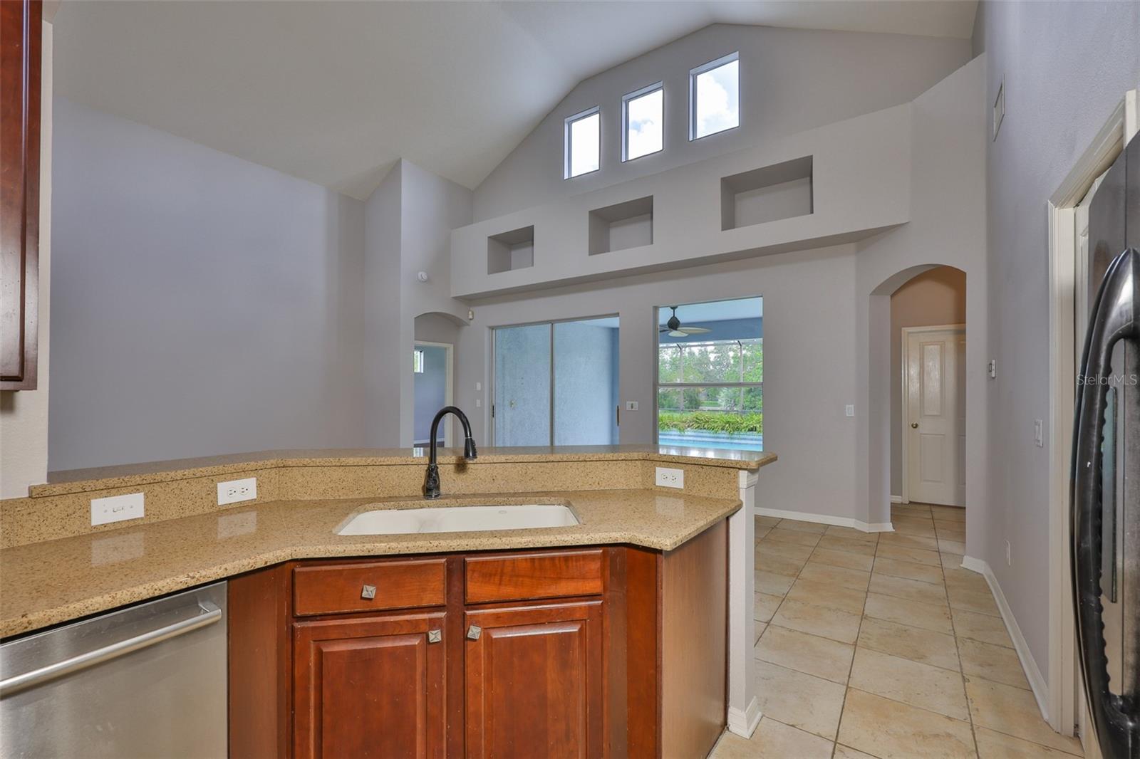 Chef's kitchen, granite counters, lots of wood cabinets, recessed lighting over cabinets and in vaulted ceiling. Breakfast bar behind sink, dinette behind breakfast bar
