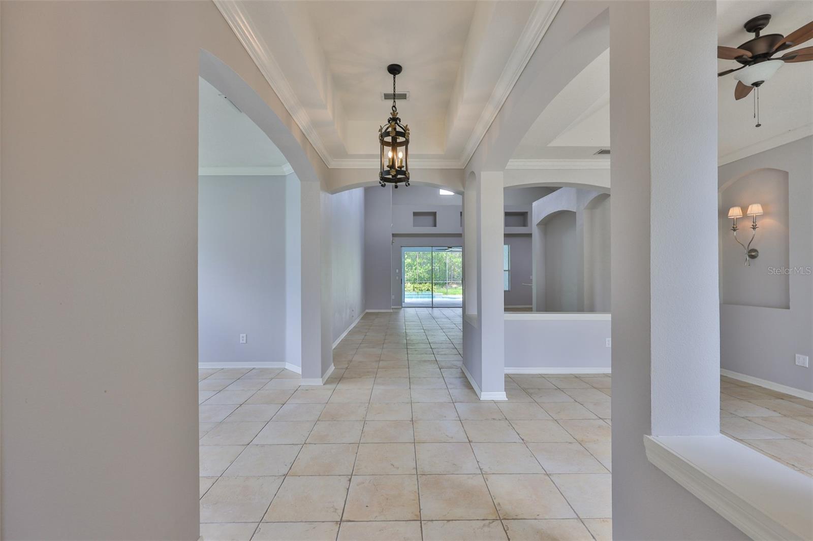 Grand foyer, formal dining on right, study/den on left, great room, pool ahead
