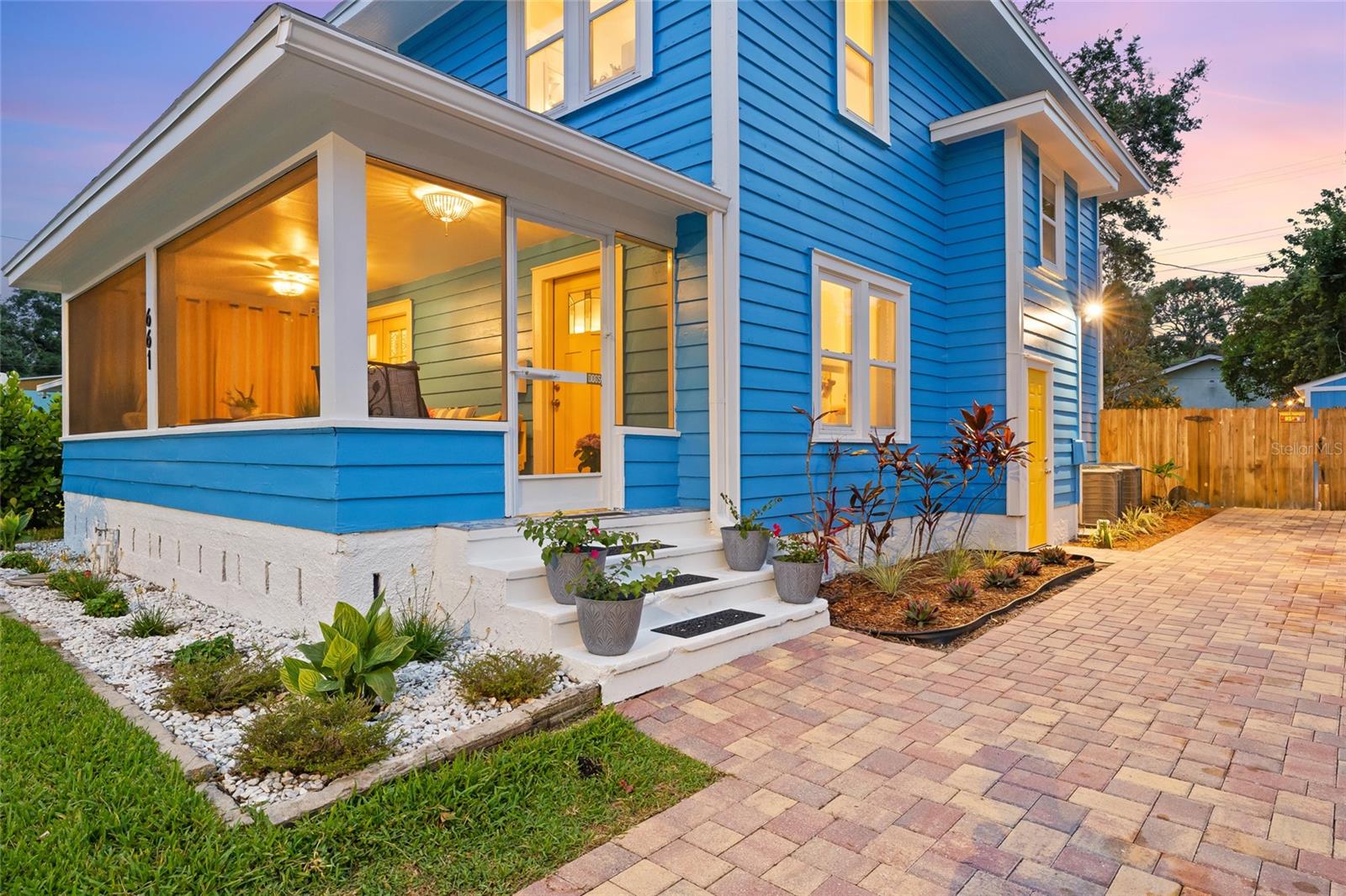 Attractive multi-color paver driveway, fresh landscaping, and entry into the home through the front or side door.
