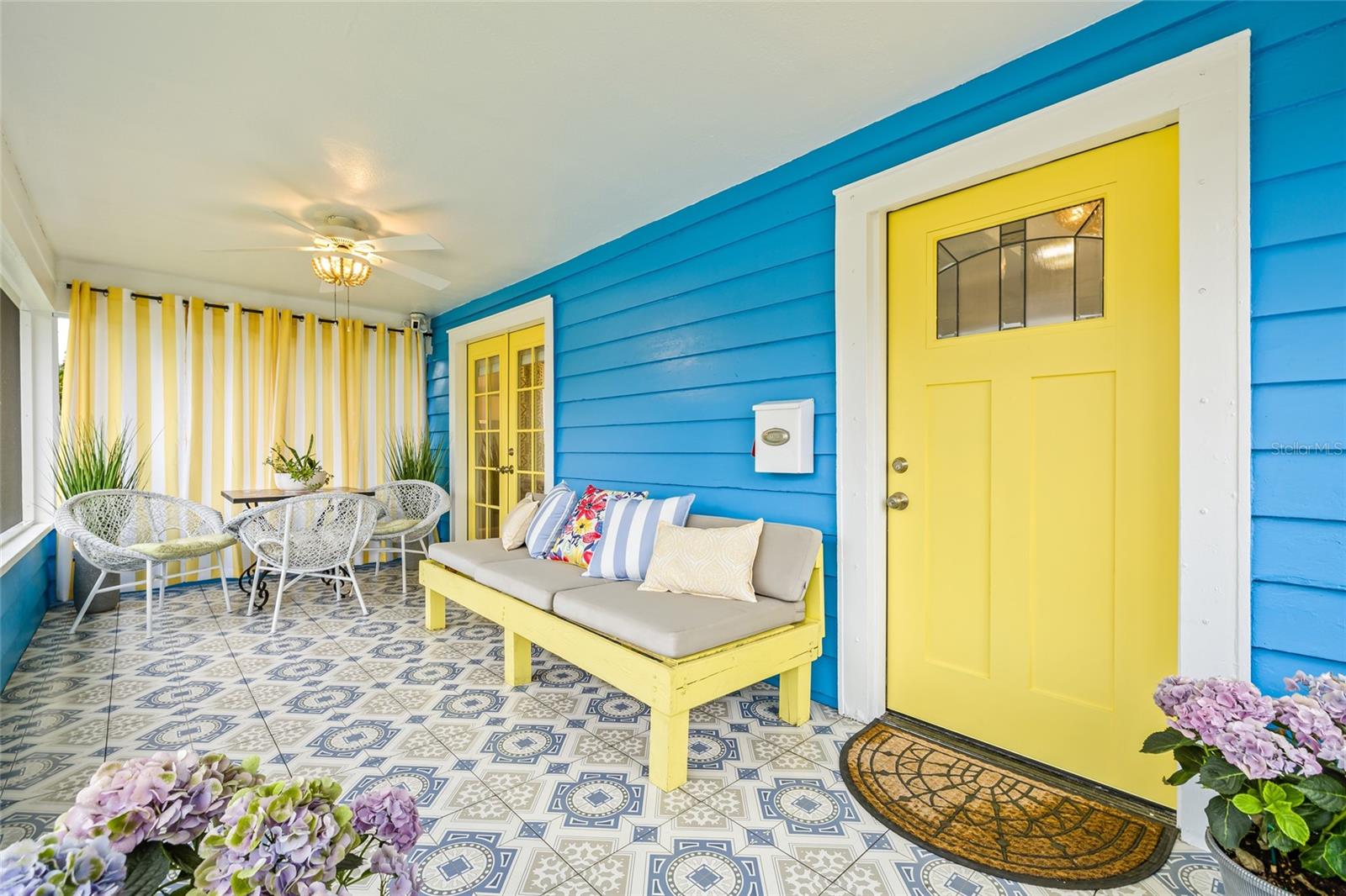 Bright and welcoming screened porch with vibrant tile and cheerful colors—perfect for relaxing or entertaining.