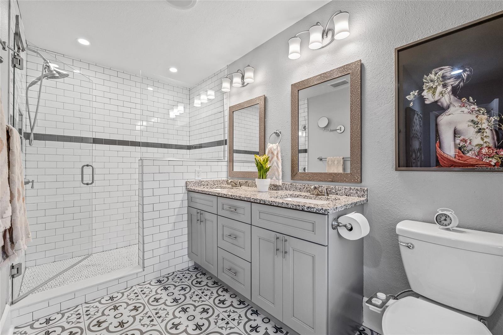 The primary barhroom has designer touches throughout, including patterned tile flooring and updated fixtures.