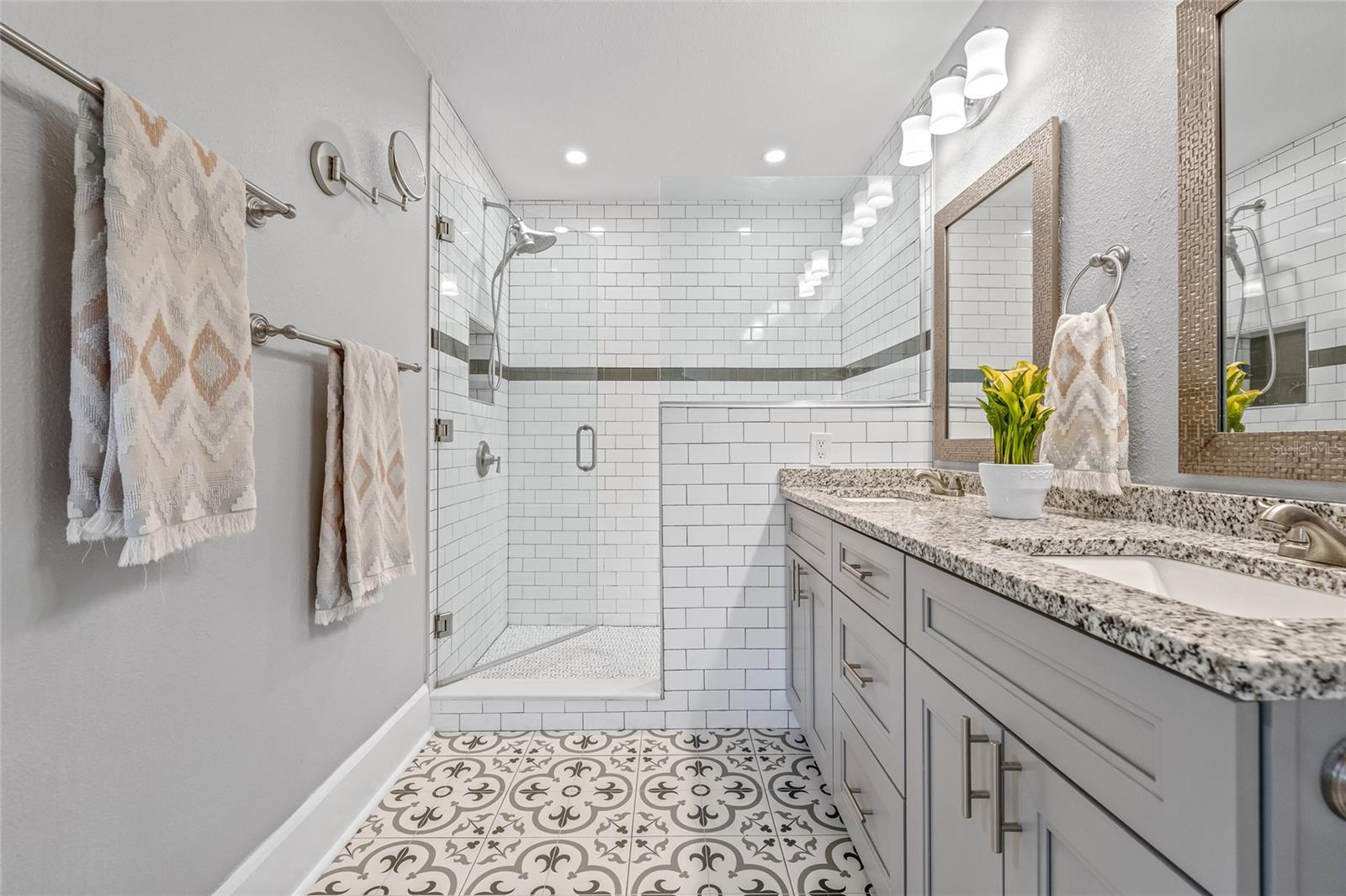 Note the stylish walk-in shower with subway tile surround, frameless glass, and sleek brushed hardware.