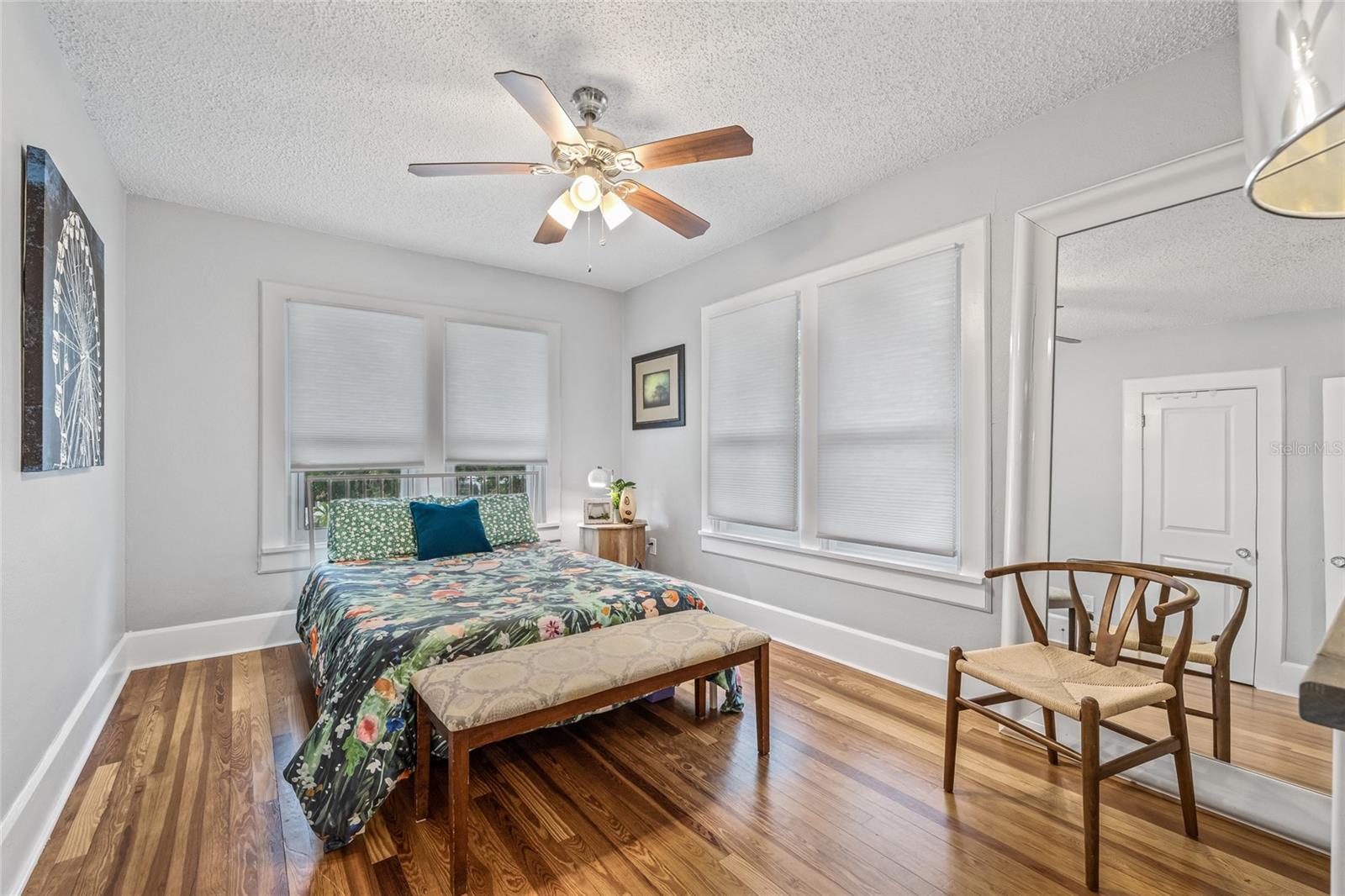 Bedroom 2 features more of the warm hardwood floors, large windows, and ample natural light.