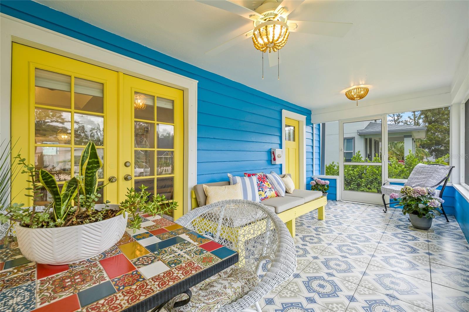 French doors, stylish light fixtures and ceiling fan round out this extended outdoor living space.
