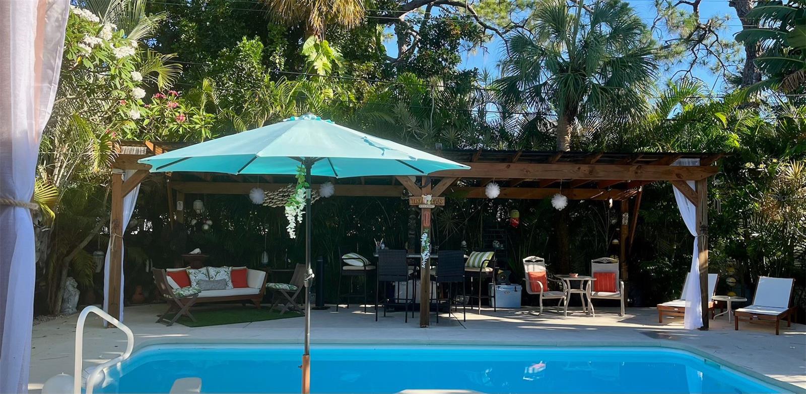 Covered area by the pool with a bar!