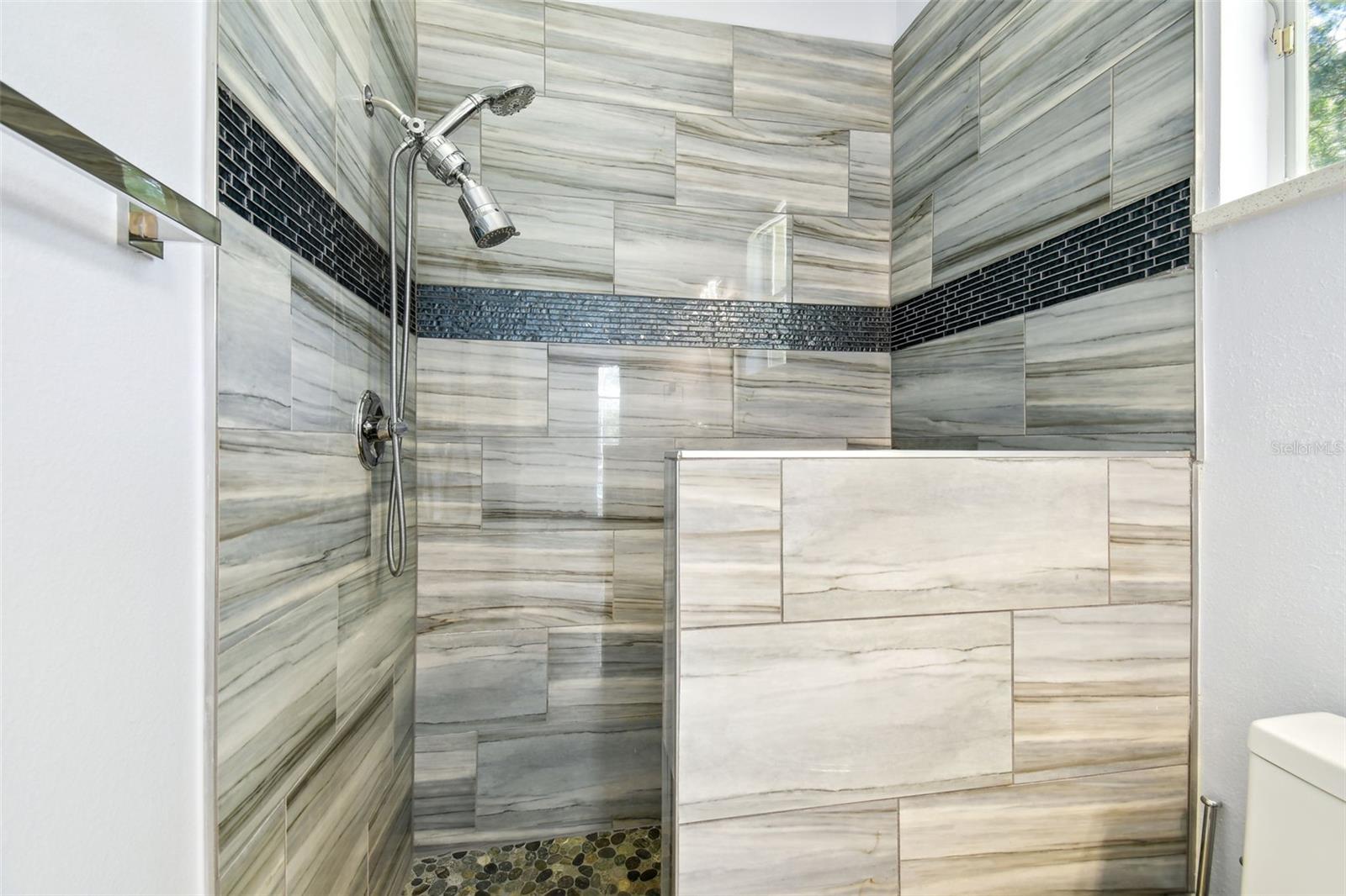 Custom in-law suite featuring a remodeled full bathroom with direct exterior access to the pool and lanai.