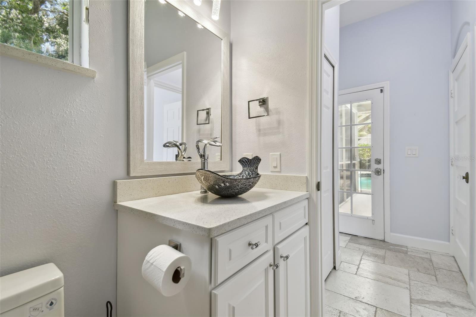 Custom in-law suite featuring a remodeled full bathroom with direct exterior access to the pool and lanai.