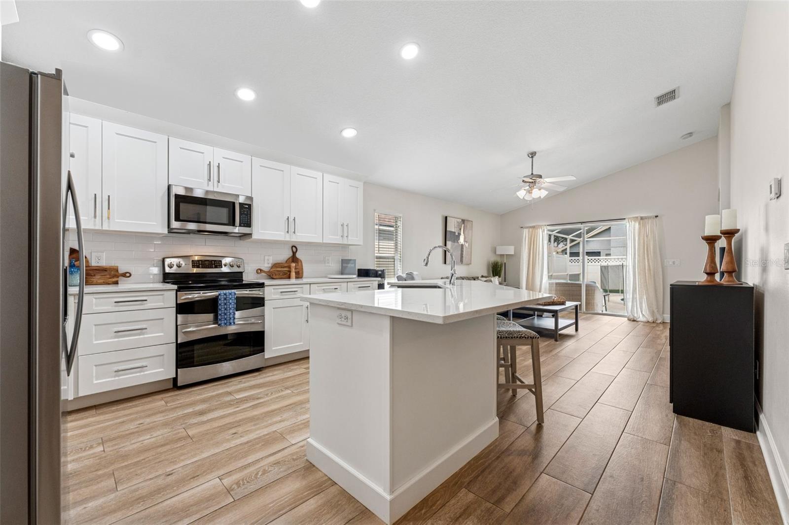 A chef's kitchen, formal dining room and open concept family room as you enter through the arched doorway.