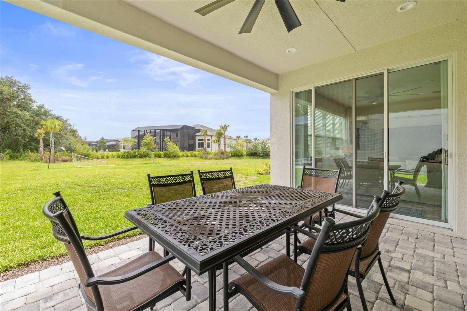Paved rear covered porch overlooking oversized yard and conservation
