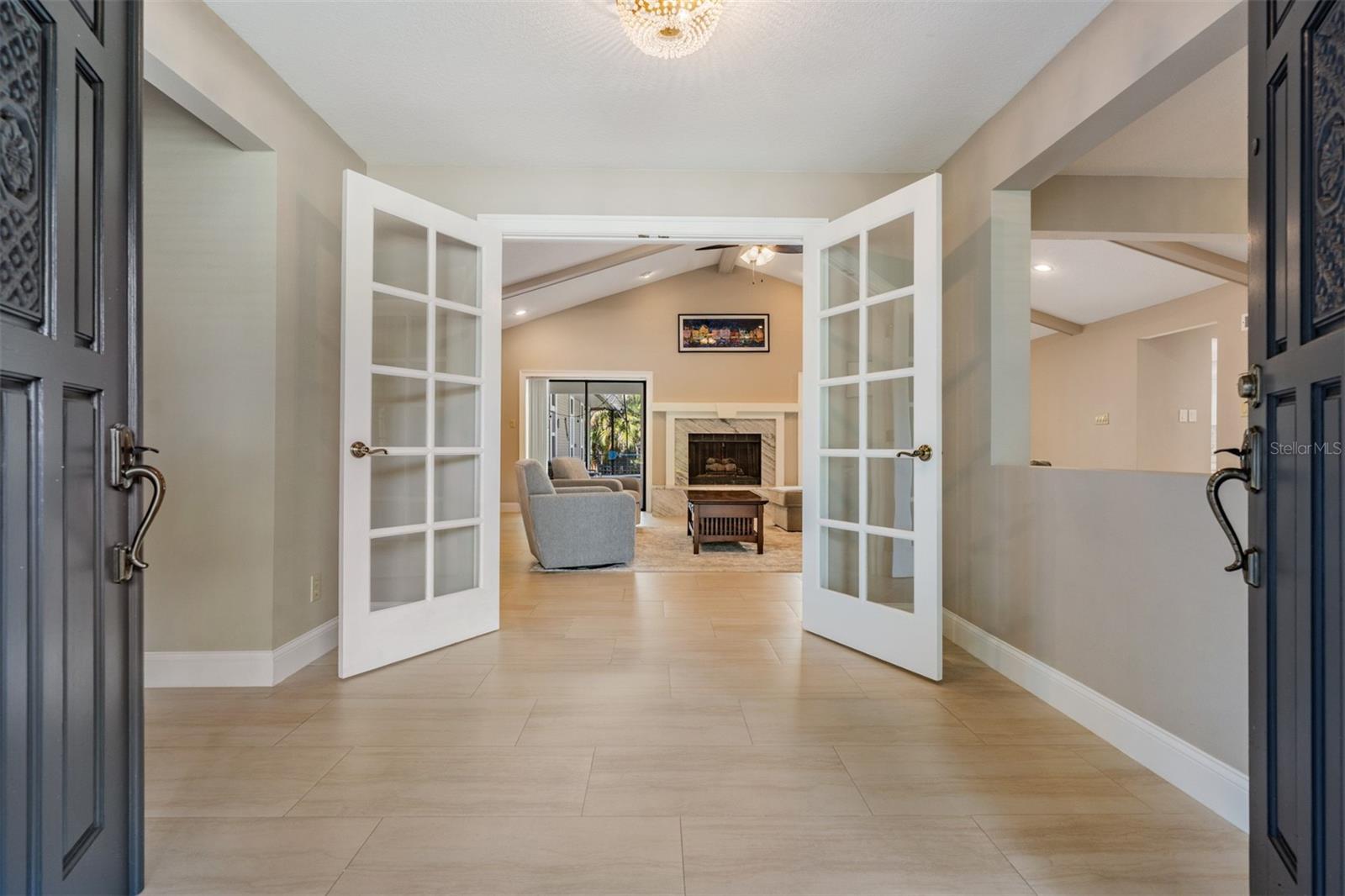 Step through the double front doors with sidelights into a spacious foyer that sets the tone for the home’s welcoming design. From here, French doors offer two inviting options—one leading into a bonus room perfect for a private office, gym, or playroom, and the other opening into the spacious living room.