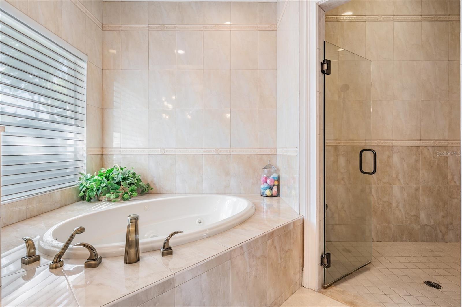 The stunning spa-inspired ensuite bath is designed to impress with dual designer stand-alone vanities, a luxurious Jacuzzi tub, a separate walk-in shower, a private toilet room, and sparkling tile finishes that add a touch of elegance to this relaxing sanctuary.