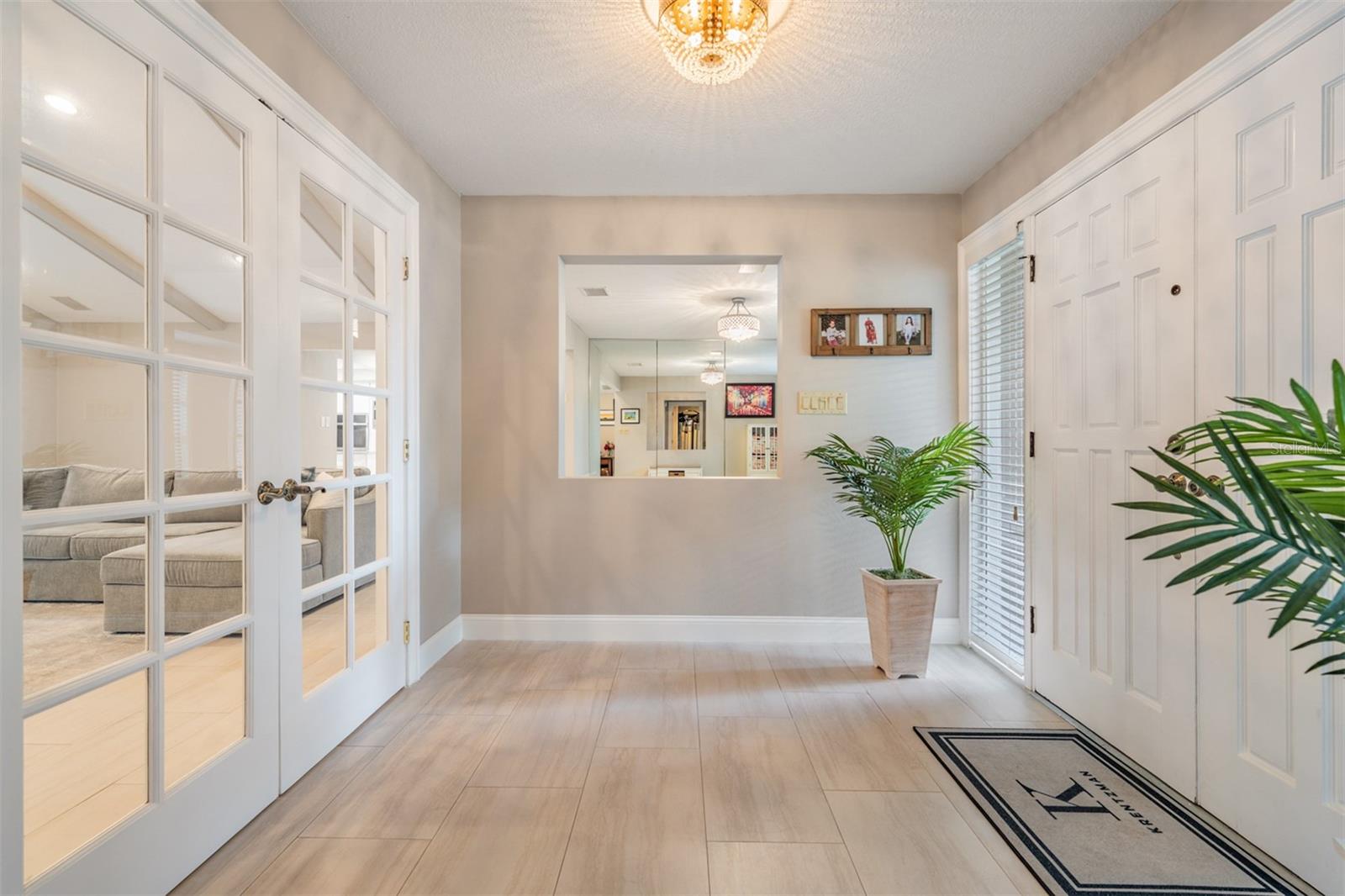 Step through the double front doors with sidelights into a spacious foyer that sets the tone for the home’s welcoming design. From here, French doors offer two inviting options—one leading into a bonus room perfect for a private office, gym, or playroom, and the other opening into the spacious living room.