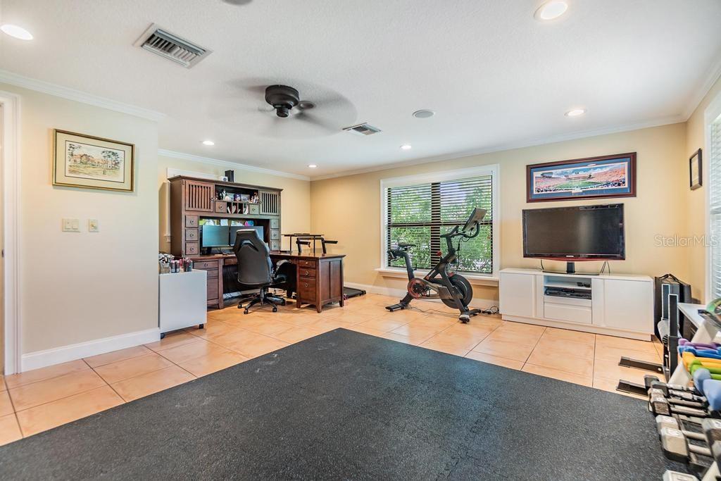 The laundry room is thoughtfully outfitted with a large-capacity washer and dryer on pedestals, a stainless-steel sink, granite folding counter, and generous built-in storage, making everyday chores a breeze.