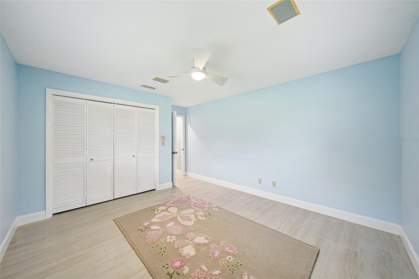 Fourth bedroom is a nice size with ceramic tile flooring, fresh paint, a wall closet and a modern fan