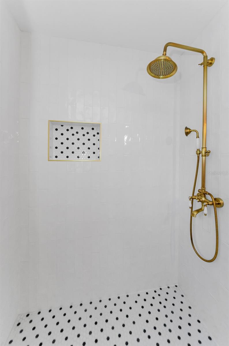 Vintage inspired tile with antique brass shower fixtures