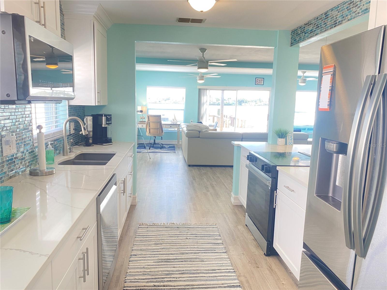 Open kitchen with quartz counters and breakfast bar