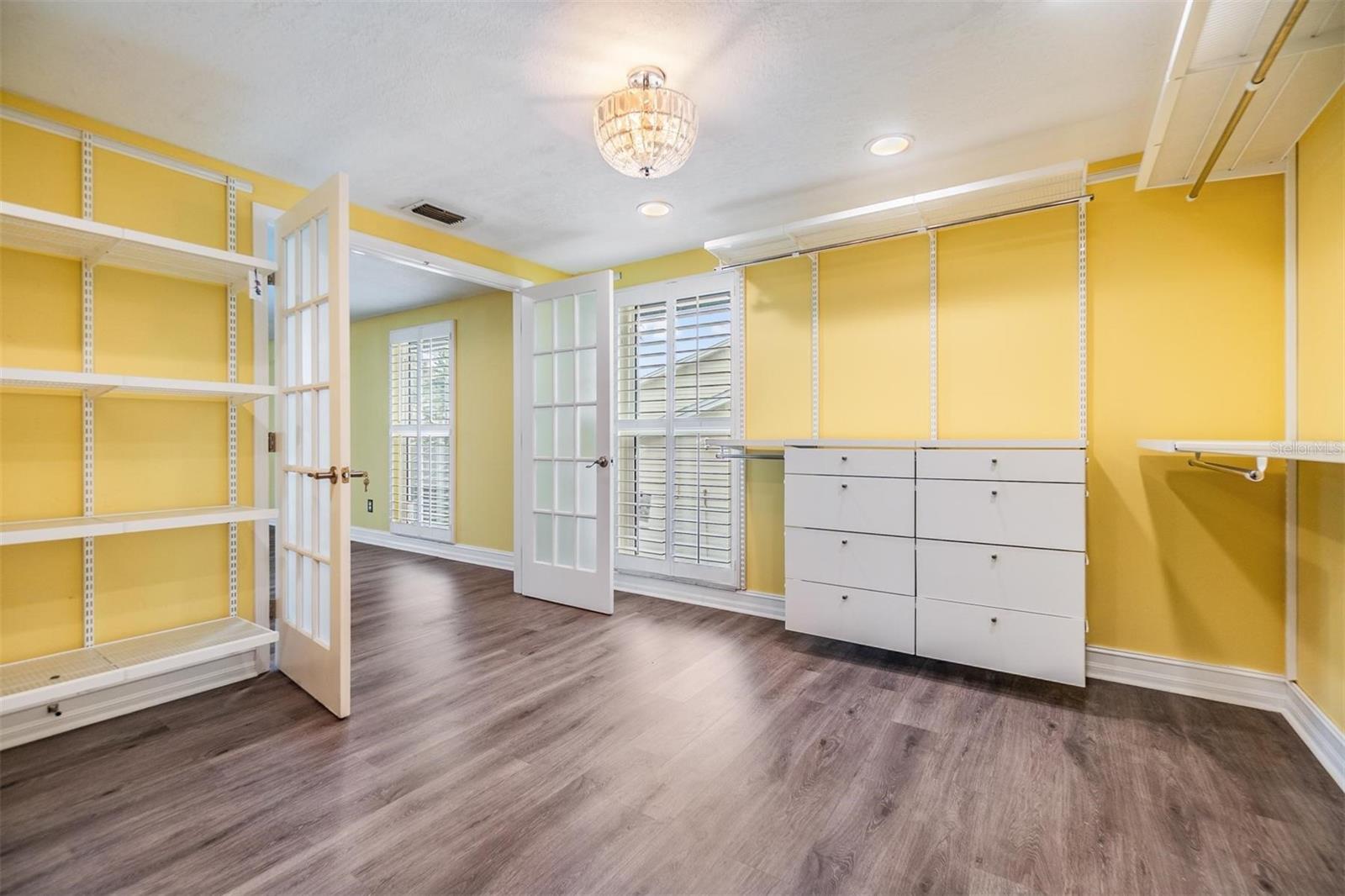 Custom shelves and a chandelier in primary closet