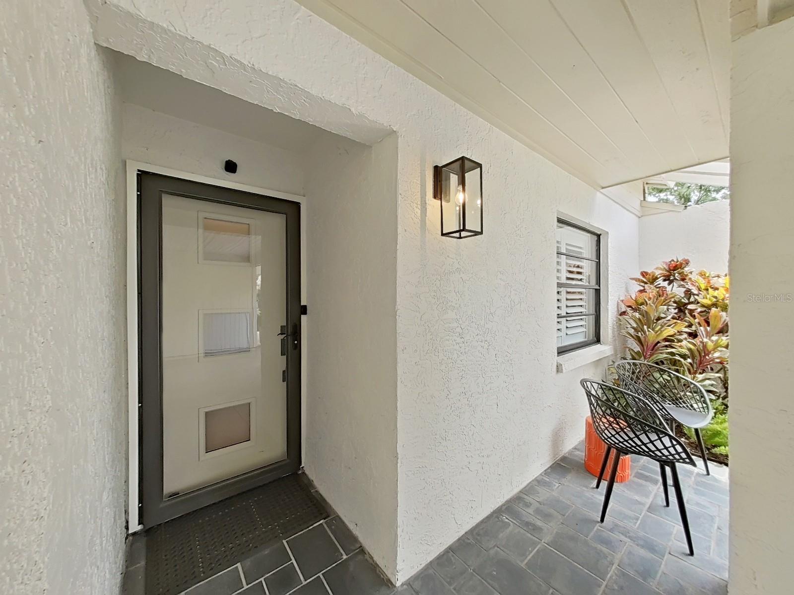 Covered front porch & door with full-view glass storm door.