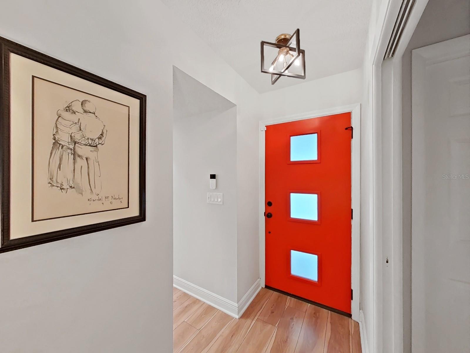Impressive front foyer entry- New front door, lighting, flooring, baseboards, and paint.