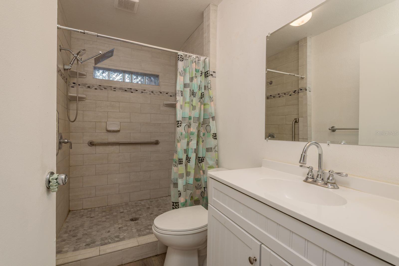 Full bathroom with tiled walk in shower.