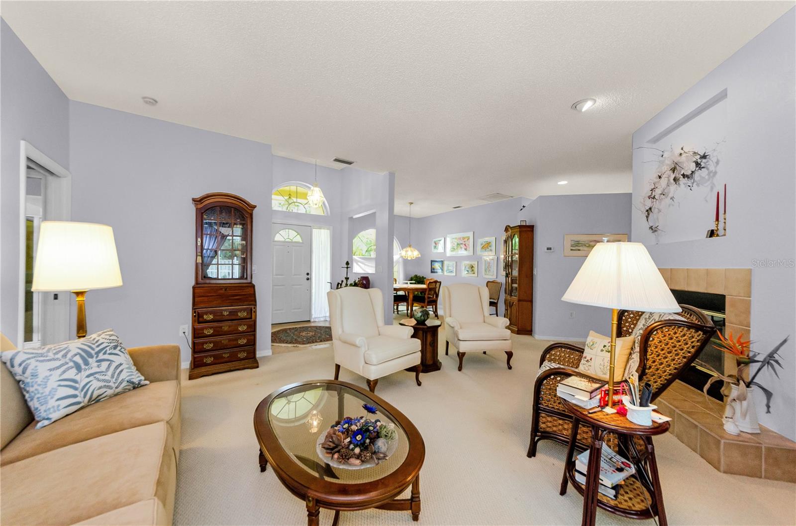 Nice open view of Living Room with fireplace, front entrance to home and Dining Room in the background.