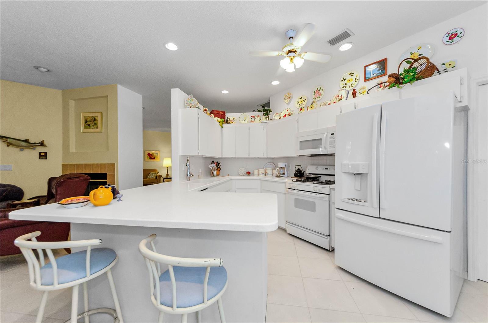 Kitchen with bar seating, newer refrigerator, microwave, dishwasher, and natural gas stove. Instant hot water system.