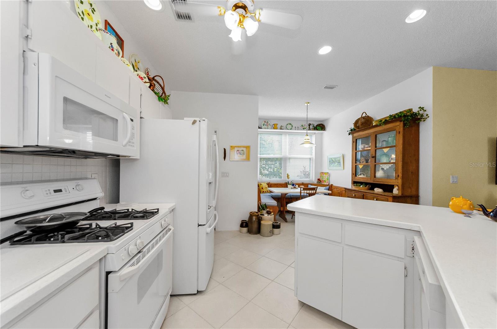 Kitchen showing natural gas range, microwave newer refrigerator, and dishwasher.