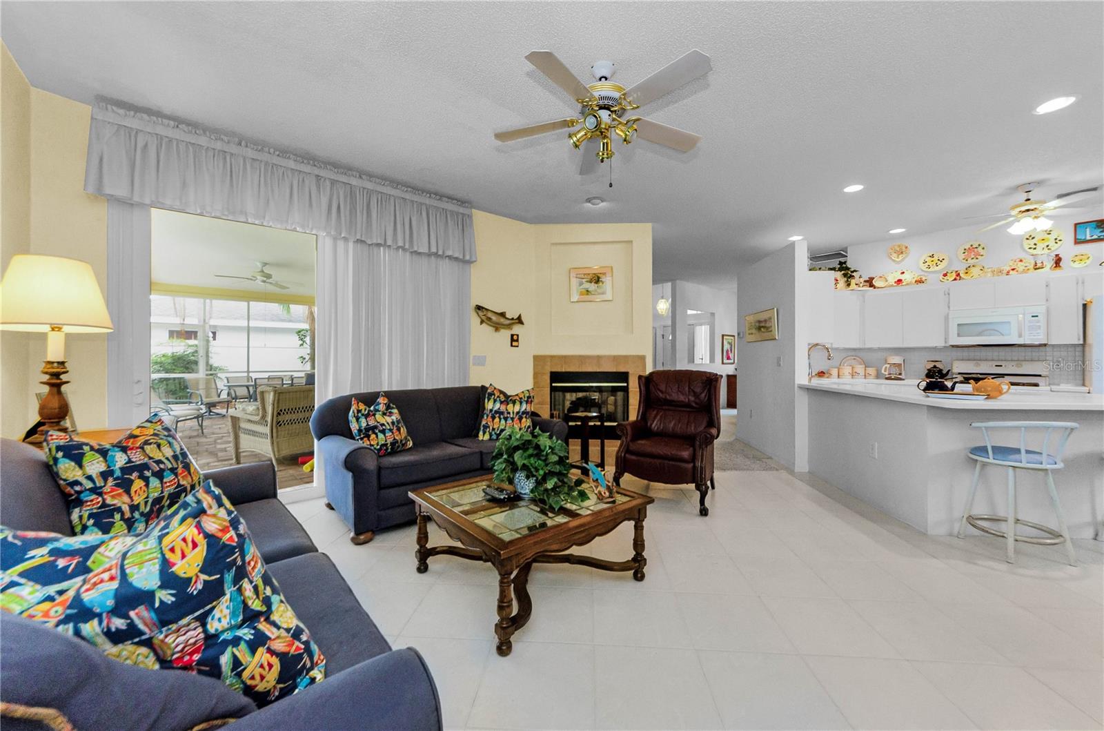 Family room and kitchen combination with two sided fireplace.  Glass sliders out to pool area.