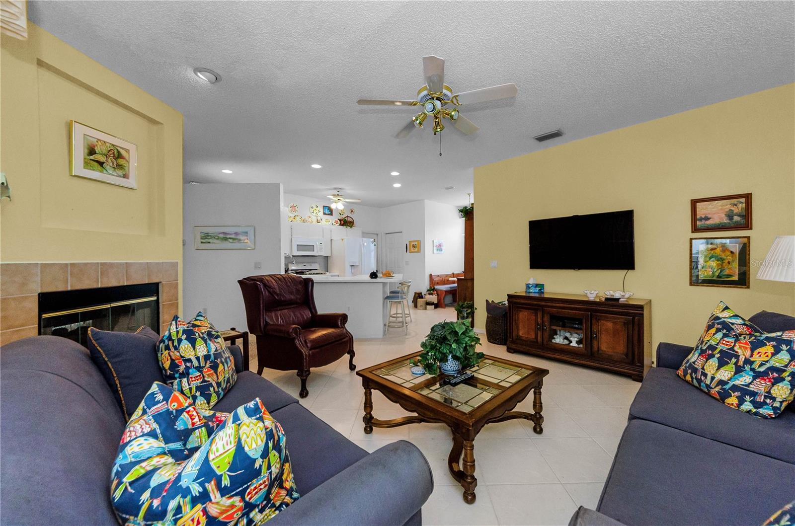Full view of family room, fireplace, TV area and kitchen in the background along with the Breakfast Nook.