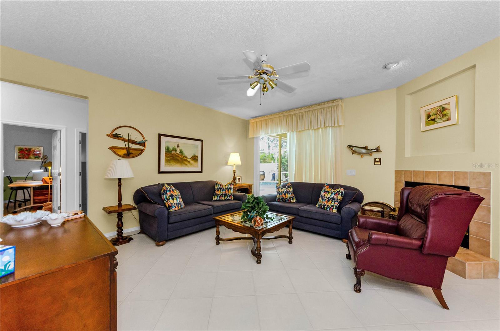 Family room off kitchen with other side of double fireplace from living room and sliders to outdoor pool and pavilion.