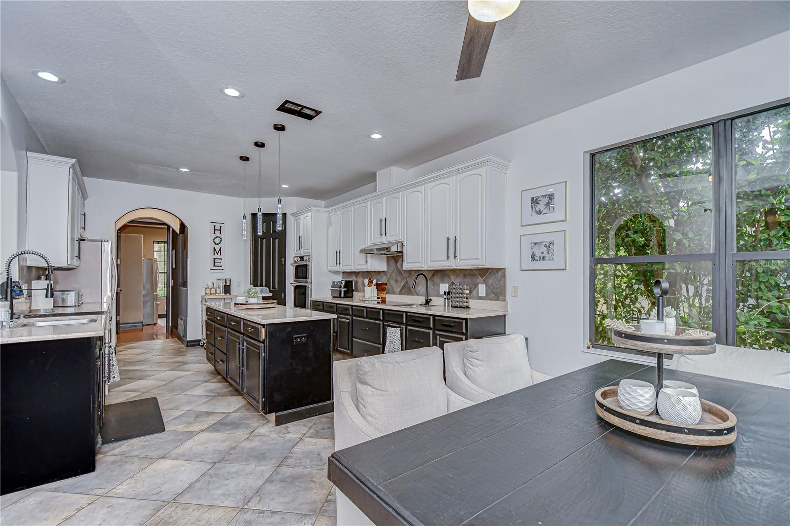 This beautifully updated kitchen features white 42” upper cabinets with crown and sleek black base cabinets!