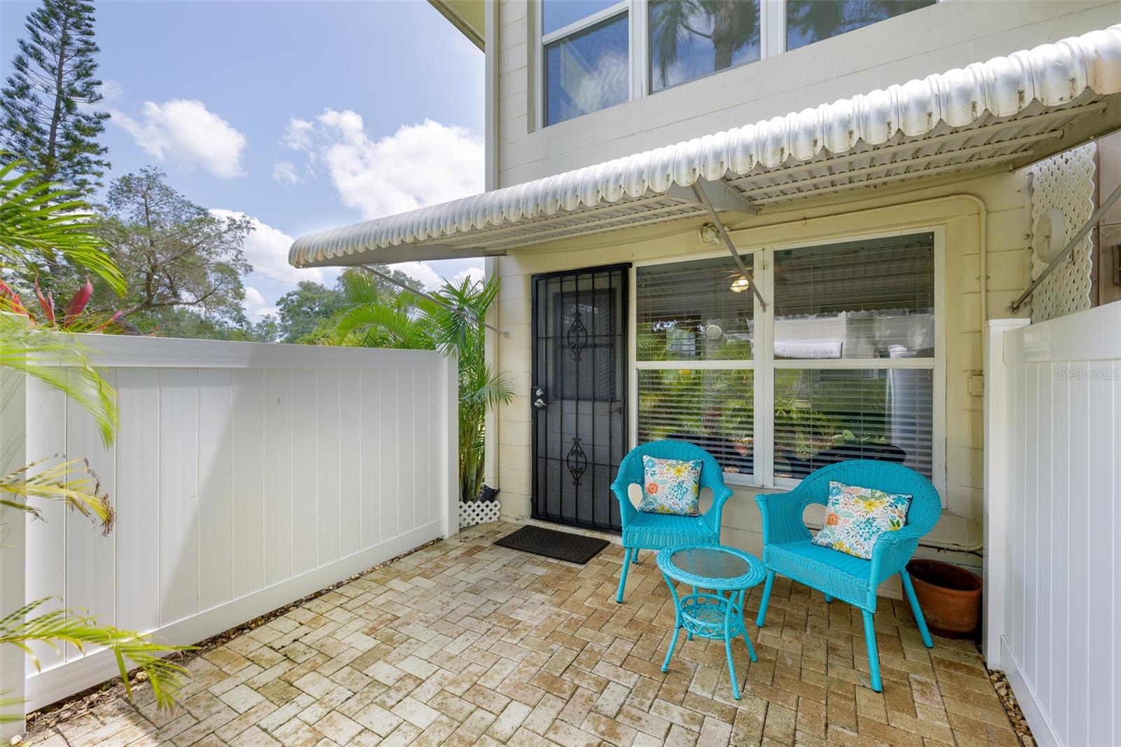 Just outside your back door, enjoy a fully fenced, paver patio with an awning for shade and space to entertain, garden, or relax in the Florida breeze.