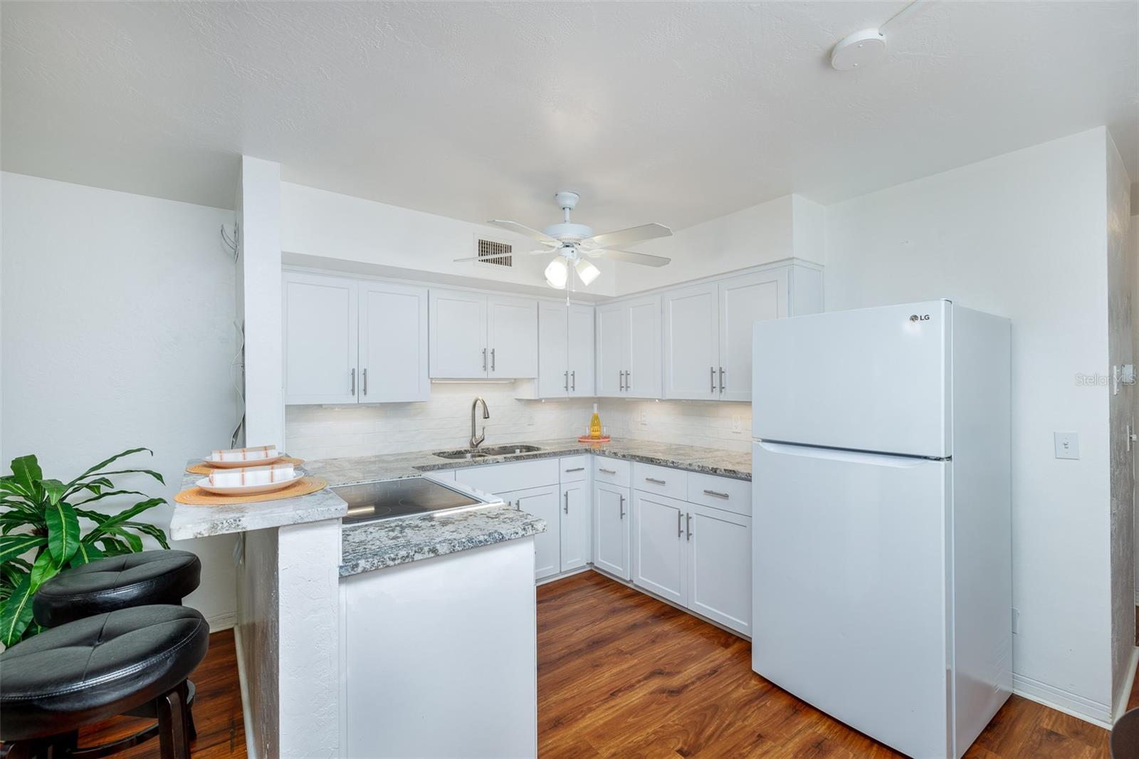 The updated kitchen features granite countertops, a breakfast bar, soft-close cabinetry, and hardwired under-cabinet lighting—modern touches throughout.