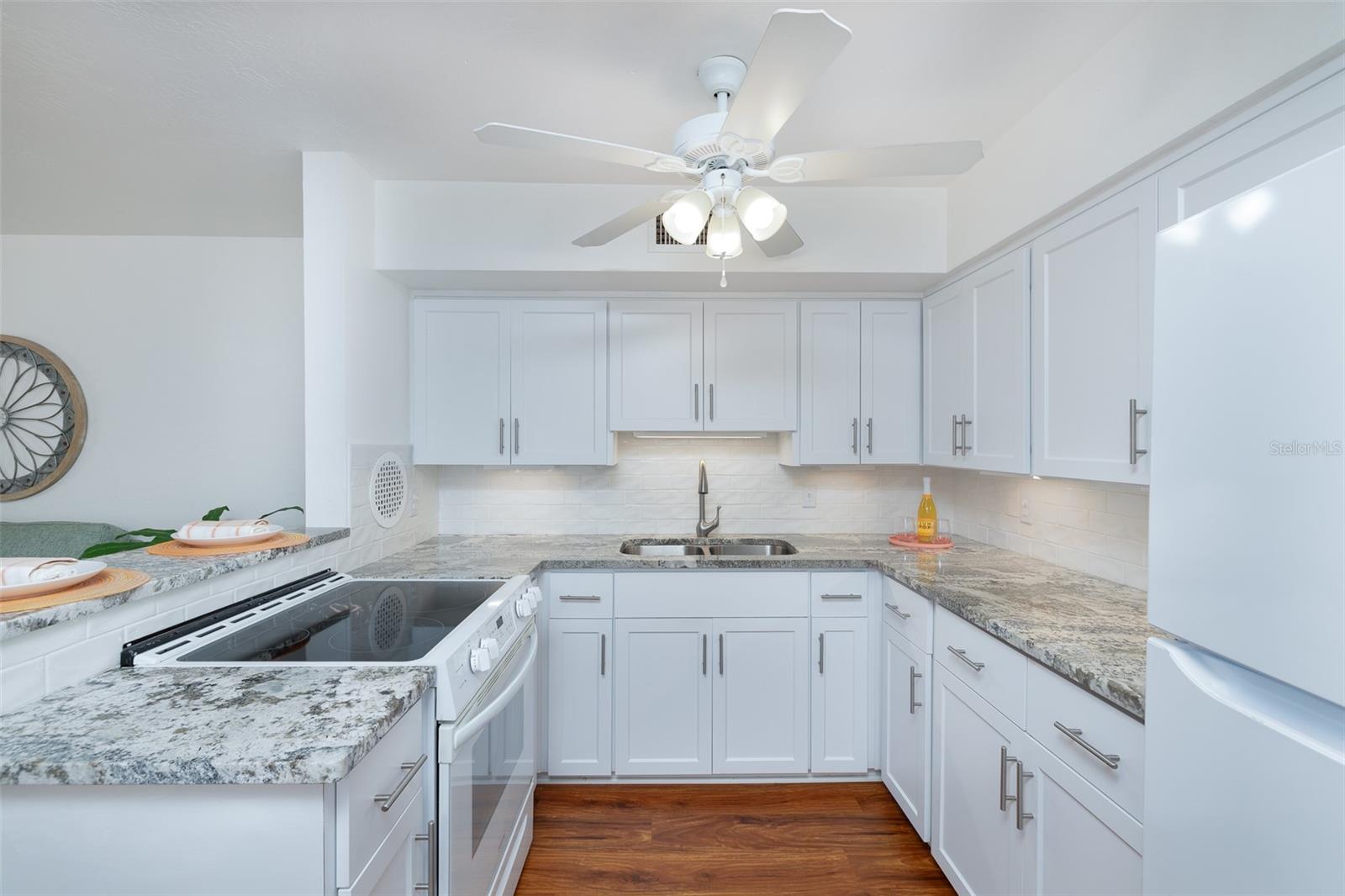 A closer look at the kitchen showcases full-size appliances, ceiling fan, and ample counter space for meal prep or morning coffee.