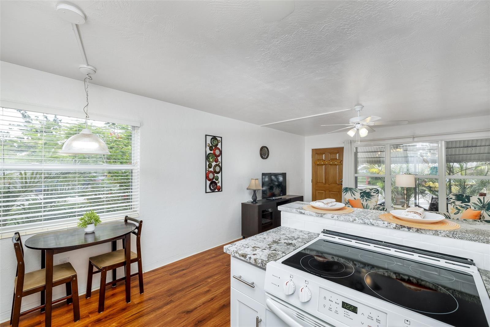 The cozy dining nook sits beside a large window, offering a peaceful spot for breakfast with garden views and natural light.