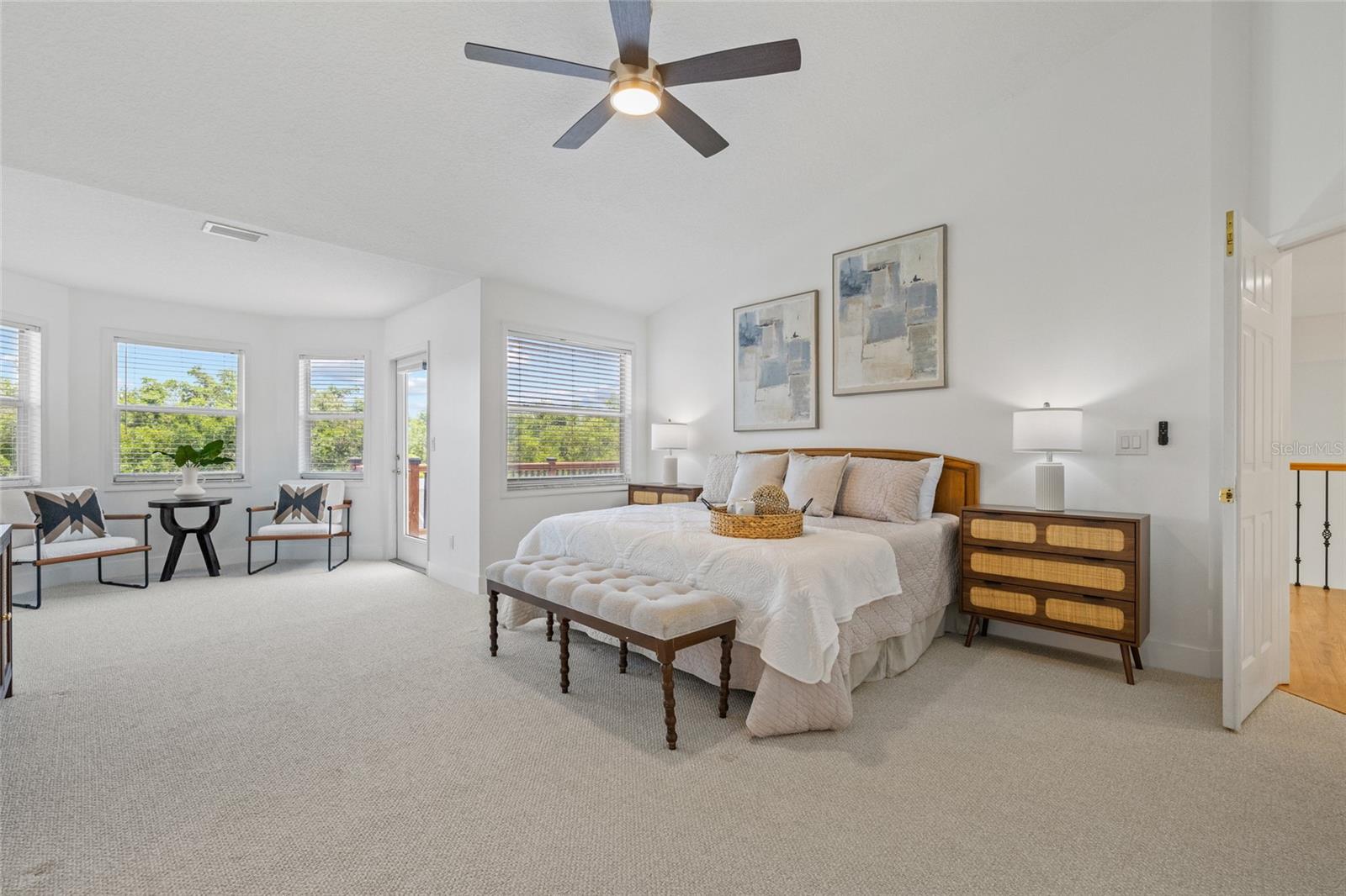 Enormous primary bedroom with sitting nook and access to the deck terrace.